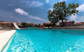 Utomhuspool, parasoller och solstolar