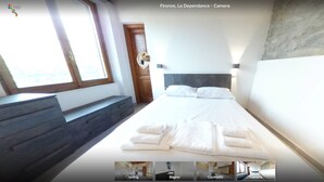Una habitación de hotel con una cama, un banco, una ventana y vista al mar.