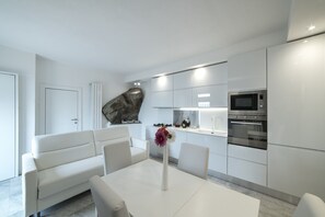 A modern kitchen with white cabinetry, a built-in oven, and a microwave. - Florence Vicinanze - Deluxe Apartment 08 (Impruneta)