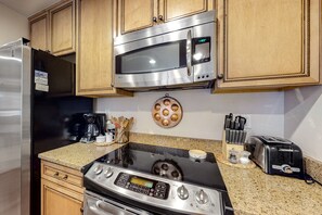 Enjoy cooking in this well-equipped kitchen with a refrigerator, microwave, stove, coffee maker, and toaster.