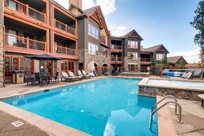 Relax by the outdoor pool surrounded by lounge chairs and umbrellas.