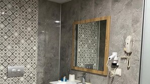 A modern bathroom with a vanity, toilet, and shower.