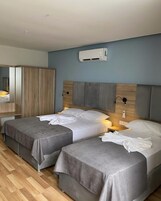 Kamar Triple Deluks, pemandangan laut | Minibar, brankas, meja kerja, dan tirai kedap cahaya