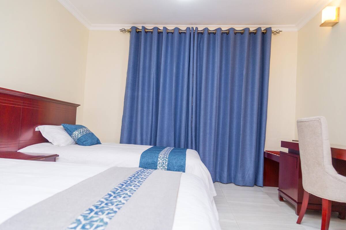Una habitación de hotel con una cama grande, un escritorio y una silla.