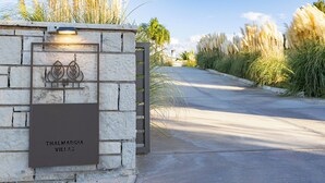 A stone wall with a sign reading "Thal Margia Villas" and a gate.