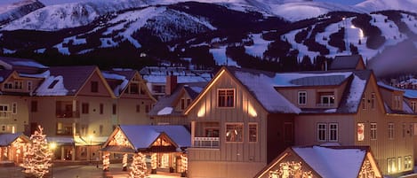 Escape to a serene mountain retreat with a charming hotel surrounded by snow-covered peaks.