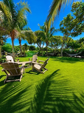A well-maintained lawn with outdoor furniture and palm trees. - Dbl Master |Oceanview |Jacuzzi |Beach |Marina |BBQ (Tavernier)