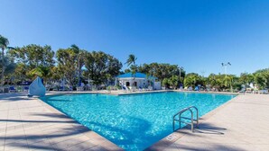 A rectangular swimming pool with a metal ladder on one side, surrounded by lounge chairs and palm trees. - Dbl Master |Oceanview |Jacuzzi |Beach |Marina |BBQ (Tavernier)