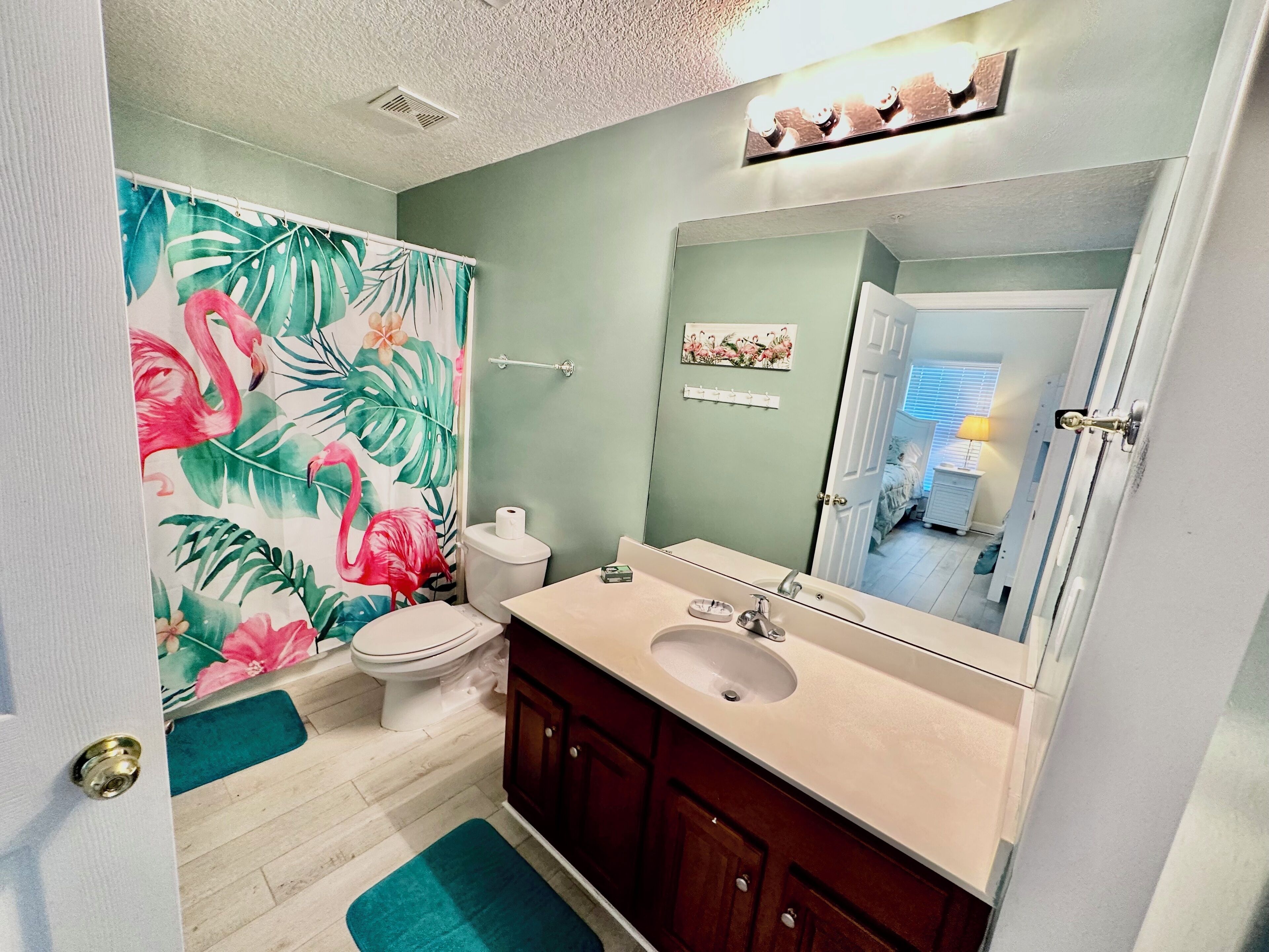 A bathroom with a toilet, sink, and mirror.
