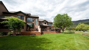 A two-story house with a deck, large windows, and a well-maintained lawn. - Dalton Ranch Townhome on 11th Fairway & Waterway - A/C - Unbeatable Views (Durango)