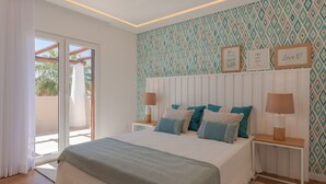A bedroom with a bed, two bedside tables, a window with curtains, and a patterned wall. - Casa da Praia - Fantastic villa located in a privileged area just few minutes to Galé beach and large pool and garden (Galé)