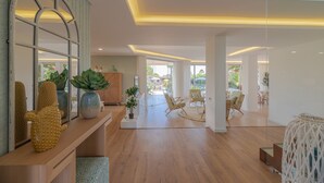 A spacious living area with a wooden floor, a large mirror, and a seating area with chairs and a table. - Casa da Praia - Fantastic villa located in a privileged area just few minutes to Galé beach and large pool and garden (Galé)