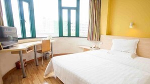 A hotel room with a bed, desk, chair, and a TV. - 7 Days Inn Suqian Fazhan Avenue (Suqian)