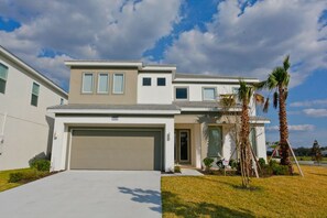 A modern two-story house with a garage, a covered front porch, and a well-maintained lawn. - All Suite 5Bed/Baths -No Carpets-New Pics coming soon- Near Disney~ (Kissimmee)