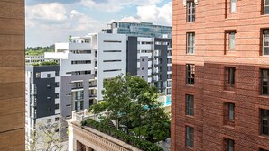 A multi-story building with a mix of modern and traditional architectural styles, featuring balconies and large windows. - Designer Apartment in The Iconic Tyrwhitt (Johannesburg)