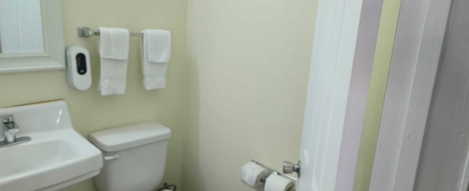 A bathroom with a sink, toilet, and hand dryer.