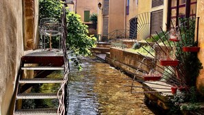 Un estrecho canal con escalones en un lado y una barandilla de metal en el otro.