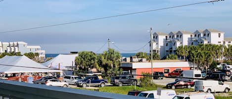 A coastal town with buildings, parked cars, and a clear sky.