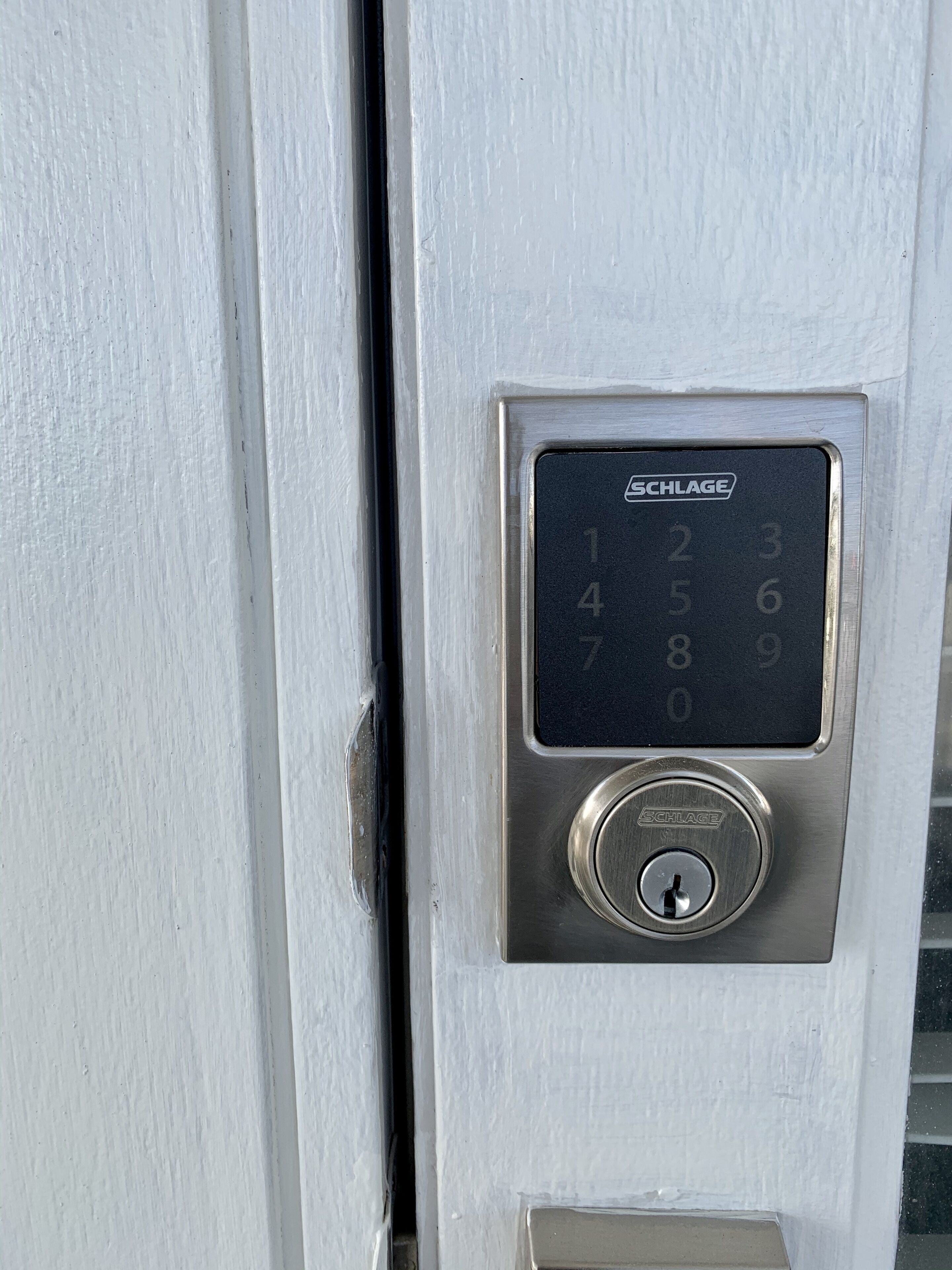 Puerta con cerradura electrónica de teclado numérico SCHLAGE.