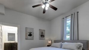 A bedroom with a large bed, a ceiling fan, and a window with curtains. - TOBIN HILL OASIS - PRIVATE POOL HOUSE 3BD/2.5BA, SCREENED IN PORCH, FULL KITCHEN (San Antonio)