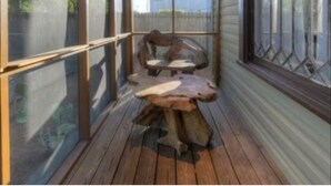 A covered porch with a wooden table and chairs, large windows, and a view of the outdoors. - TOBIN HILL OASIS - PRIVATE POOL HOUSE 3BD/2.5BA, SCREENED IN PORCH, FULL KITCHEN (San Antonio)