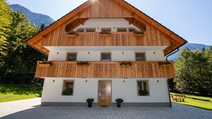 Eine zweistöckige Holzhütte mit Balkon, einer Tür und Blumentöpfen.
