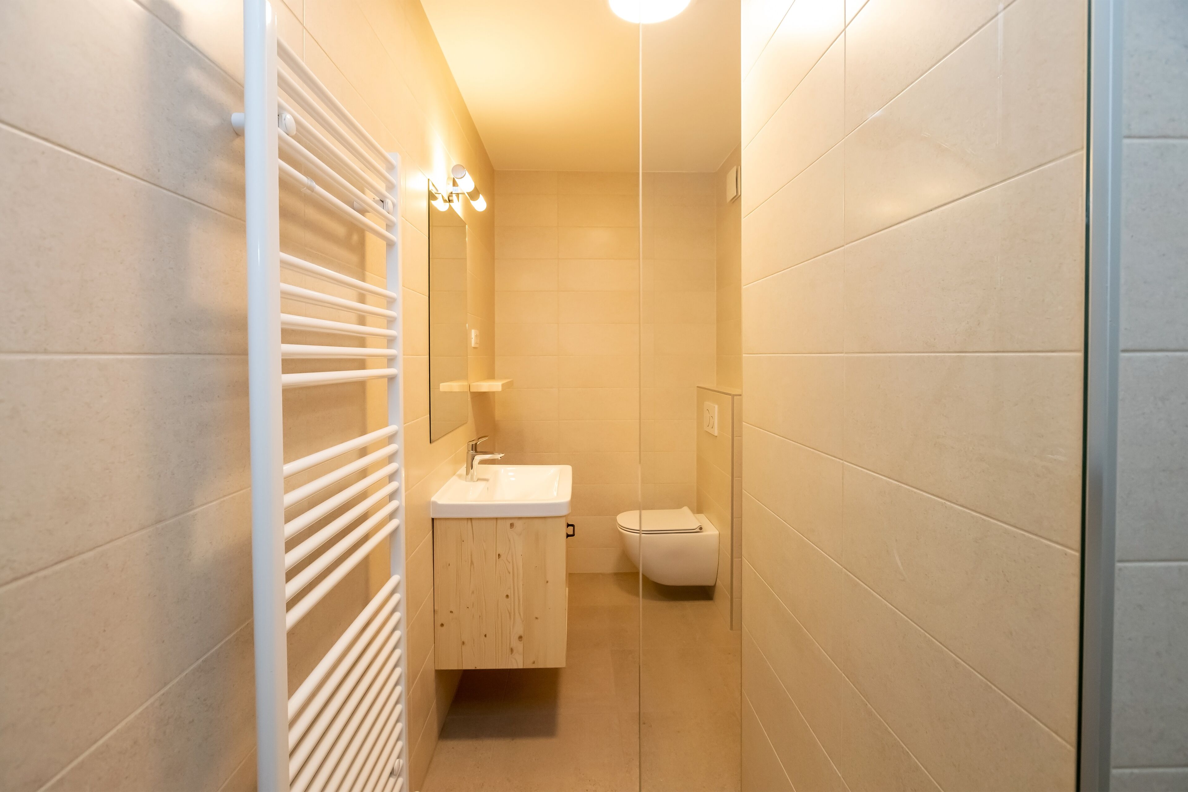 Une petite salle de bain avec un lavabo blanc, des toilettes et un porte-serviettes.
