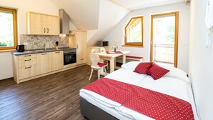 Ein Schlafzimmer mit Bett, Schreibtisch und Küchenzeile.