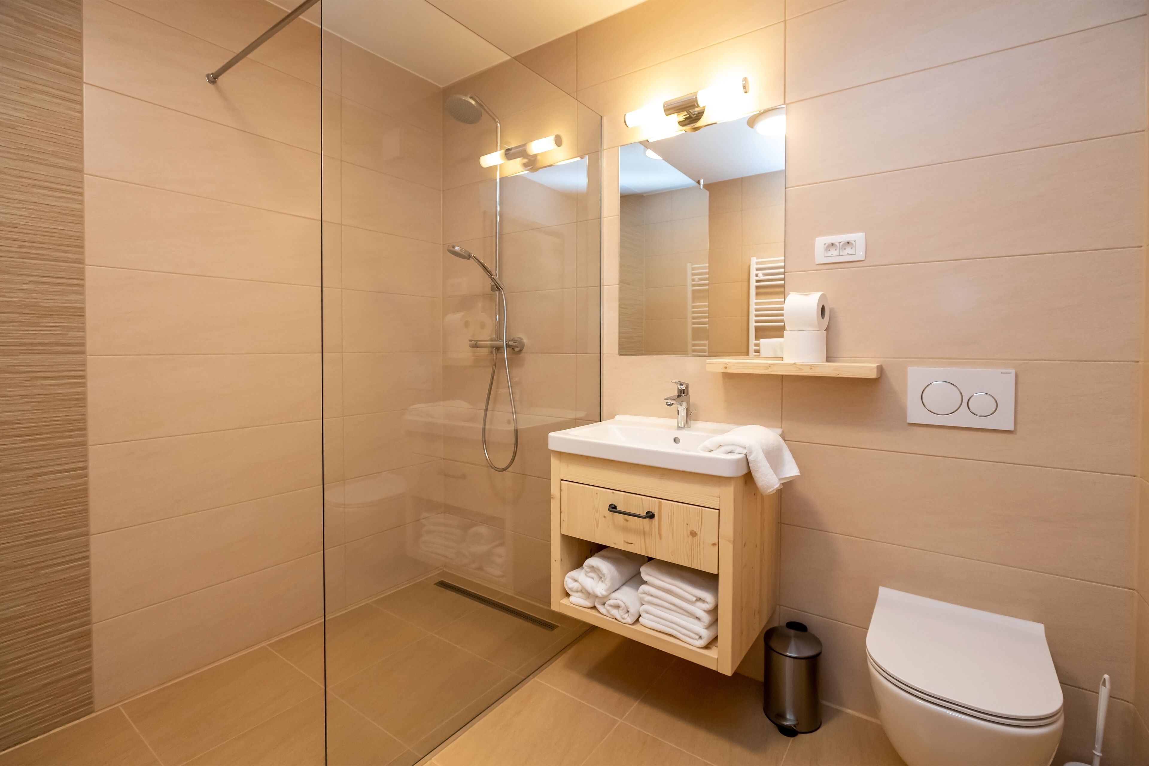 Une salle de bain moderne avec une douche à parois de verre, un lavabo blanc et des toilettes.