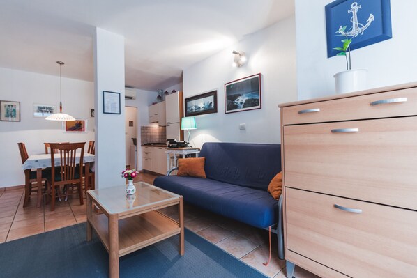 A compact living space with a sofa, dining table, and kitchenette.