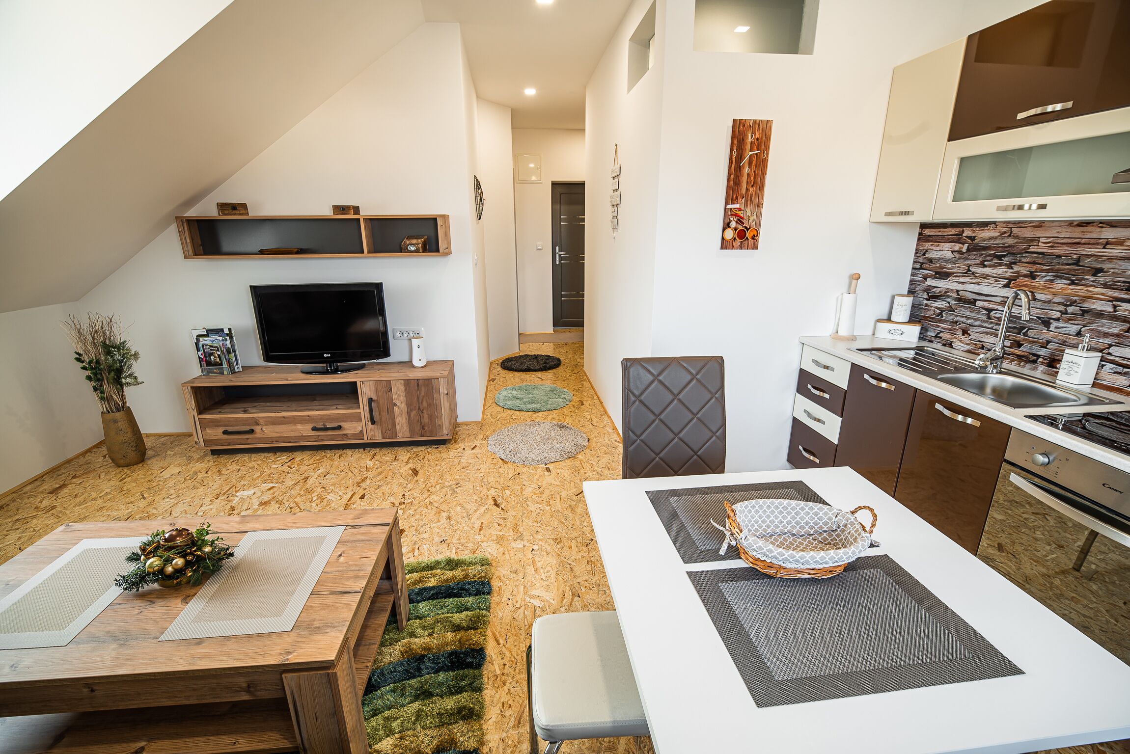 Eine moderne Küche mit Steinrückwand, Holzschränken und einer eingebauten Mikrowelle.