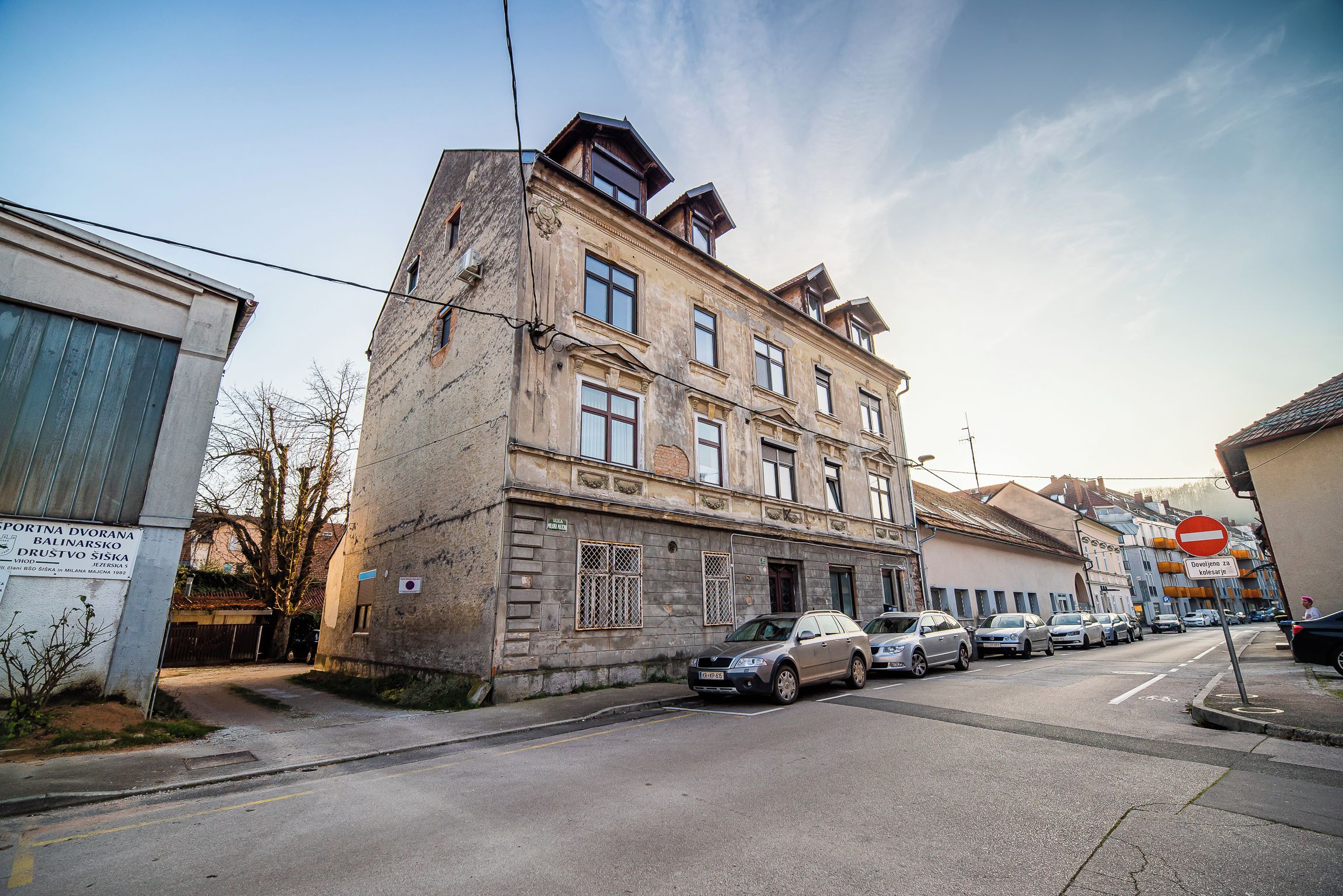 Un immeuble à plusieurs étages avec un parking situé à l’avant.