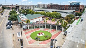 Un estacionamiento con un edificio que muestra la inscripción "DALLAS FARMERS MARKET" al fondo.