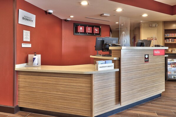 A hotel reception desk with a sign for 'Marriott Bonvoy' and a 'Manager on Duty' sign.