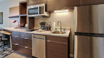 Una cucina moderna con elettrodomestici in acciaio inossidabile, un forno a microonde integrato e una macchina da caffè.