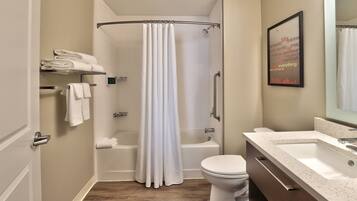 A bathroom with a shower, toilet, and sink.
