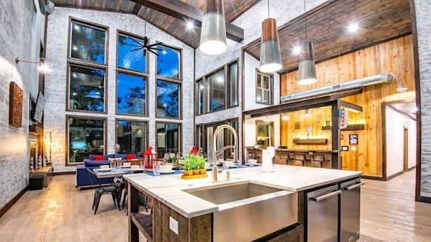 Cocina moderna con una isla grande, electrodomésticos de acero inoxidable y una zona de bar.
