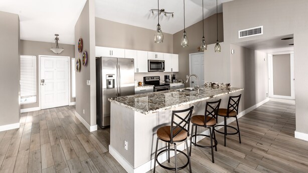 A spacious kitchen with a central island, stainless steel appliances, and pendant lighting. - The Diamond - Private Pool / Pet Friendly / 4BD Near Arena (Phoenix)