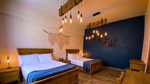 Ein Doppelbett mit Holz-Kopfteil, ein Nachttisch mit Lampe und Wanddeko aus Makramee.