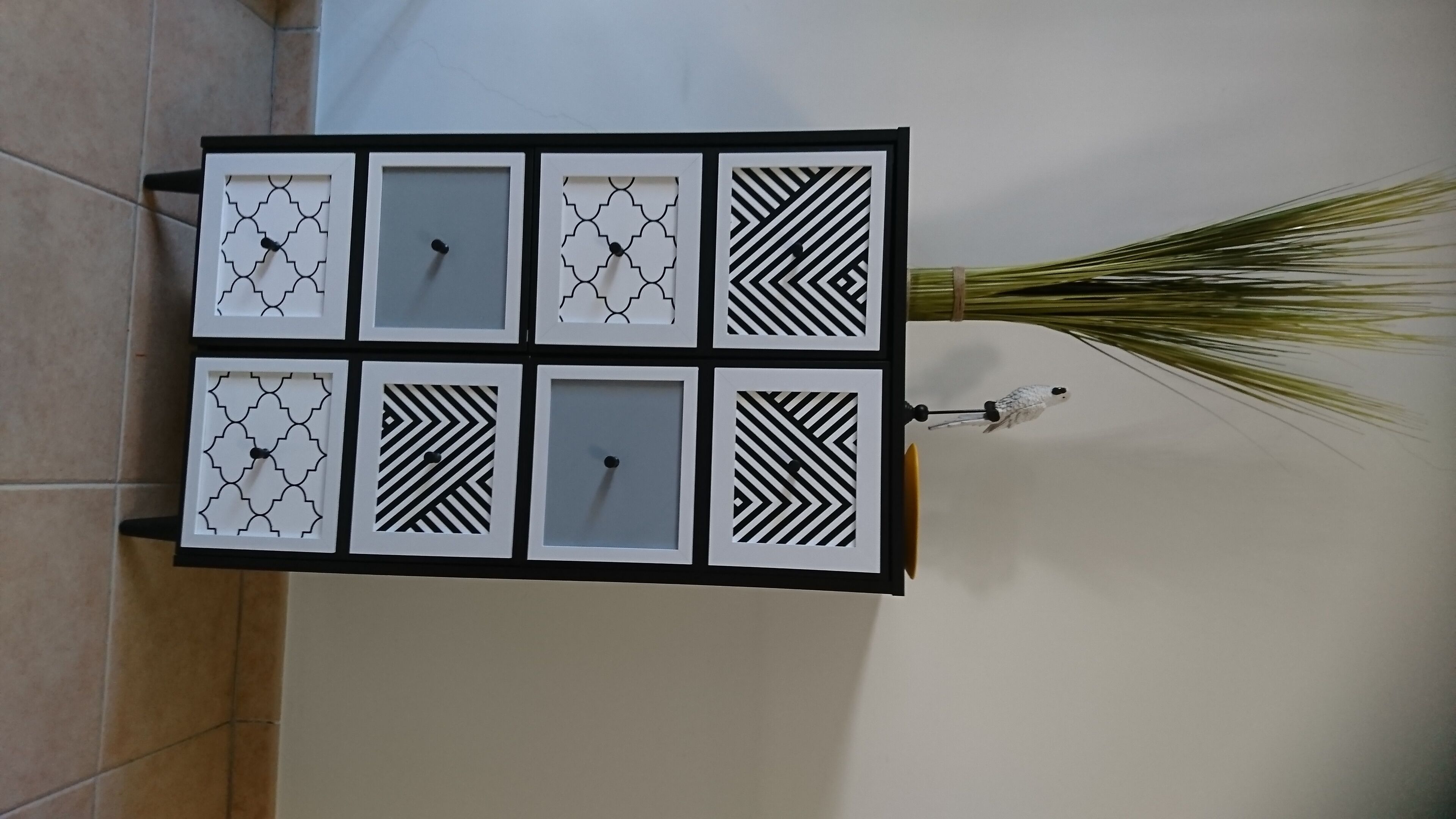 Eine wandmontierte Anzeige mit sechs quadratischen Feldern, jedes mit einem anderen geometrischen Muster.