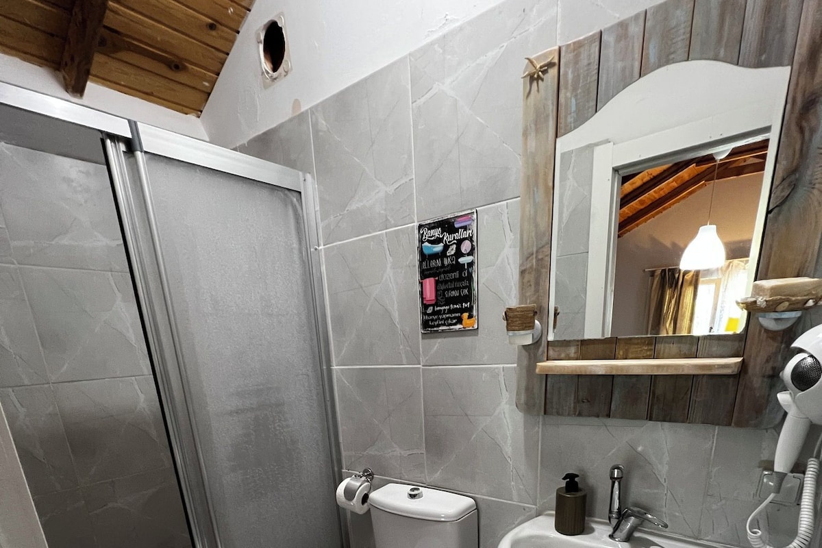 A bathroom with a toilet, sink, and shower.