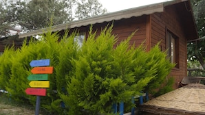 Una cabaña de madera con un cartel que indica las direcciones a Atenas, Hera, Bendis y otros lugares.
