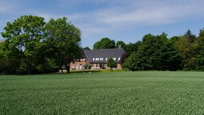 Un vaste champ dégagé, avec un bâtiment visible à l’arrière-plan.