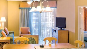 A hotel room with a dining area, a television, and a ceiling fan. - Two Bedroom Deluxe Luxury Condo, Destin Florida (1985476) (Destin)