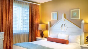 A hotel room with a large bed, a nightstand, a lamp, and two framed pictures on the wall. - Two Bedroom Deluxe Luxury Condo, Destin Florida (1985476) (Destin)