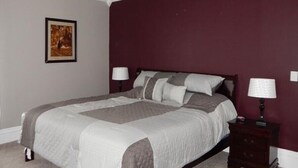 A bedroom with a bed, a nightstand, a lamp, a ceiling fan, and a framed picture on the wall. - WATKINS GLEN GUEST HOUSE, CLOSE TO EVERYTHING! (Watkins Glen)