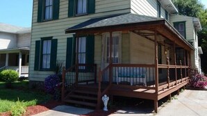 A two-story house with a covered porch and a small garden area. - WATKINS GLEN GUEST HOUSE, CLOSE TO EVERYTHING! (Watkins Glen)