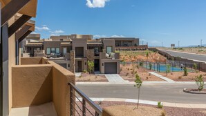 Um complexo residencial moderno com vários edifícios, piscina e paisagismo bem cuidado.