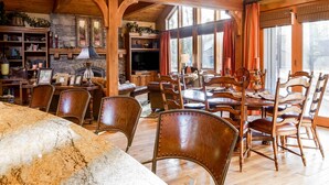 A spacious dining area with wooden furniture and a stone fireplace. - Sunriver Retreat with Access to The Cove (Sunriver)