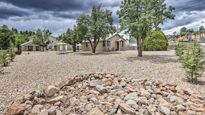 Una zona residencial con casas, un camino de grava y un muro de piedra.